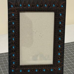 Metal Morrocon style picture frame with blue rhinestones.